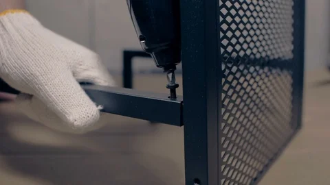 Man working drives the screw table leg with a screwdriver Stock Footage 92155621