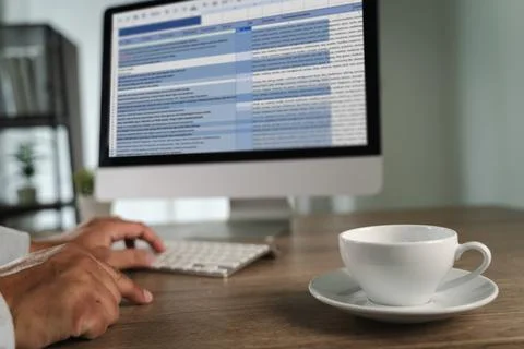 A man working on excel person working desk with computer and coffee cup, mode 스톡 사진
