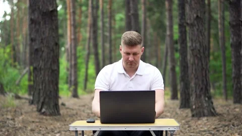 Man working in the Forest with Laptop and Smart Phone Stock Footage 138631918