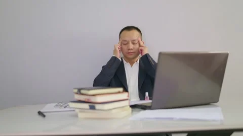 A man working in front of computer massages his temples to relax. Stock Footage 320093982