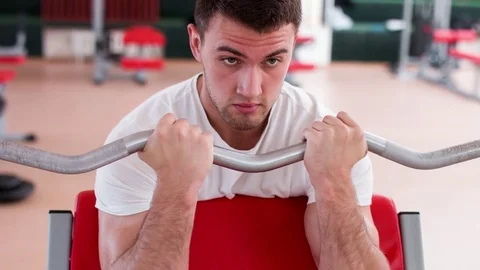 Man working his arms at the gym. He lifting the dumbbells and working his biceps Stock Footage 75762045