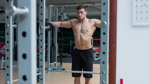 Man working his arms at the gym. He lifting the dumbbells and working his biceps Stock Footage 75763476