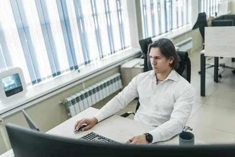 Man working at his computer in a modern office space. Stock-Fotos