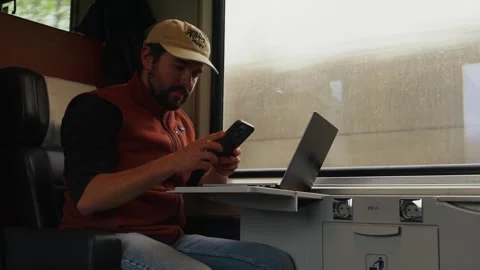 A Man is Working on His Laptop Inside a Train When He Receives a Phone Call - 動画素材 333795717