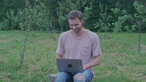 A man is working on his laptop in the park. Work things. Freelance. Stock Footage 157404652