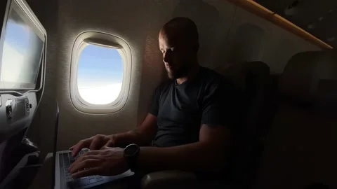 Man working on his laptop while flying in the airplane Stock-Footage 154612307