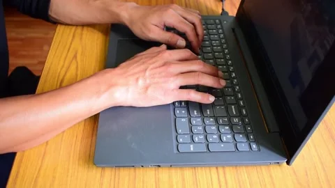 MAN WORKING ON HIS PERSONAL LAPTOP Stock Footage