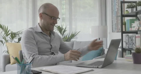 Man working from home and video calling his colleagues Stock Footage 162307939
