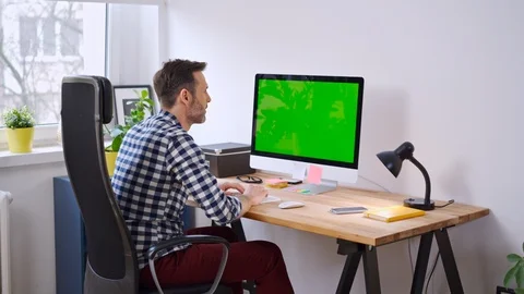 Man working from home on computer with visible chromakey screen Stock Footage 126827215
