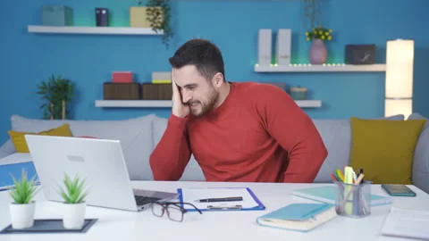 The man working from home gets stressed and frustrated by what he sees. Stock-Footage 233103933