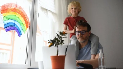 Man working from home with laptop during quarantine. Home office and parenthood Stock Footage 128901449