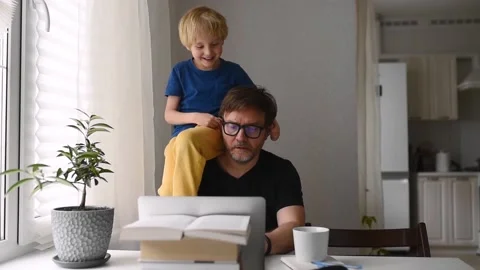Man working from home with laptop during quarantine. Home office and parenthood Stock Footage 130862789