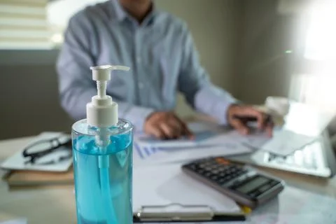 Man working from home lockdown covid 19 coronavirus using antiseptic gel soci Stock-Fotos