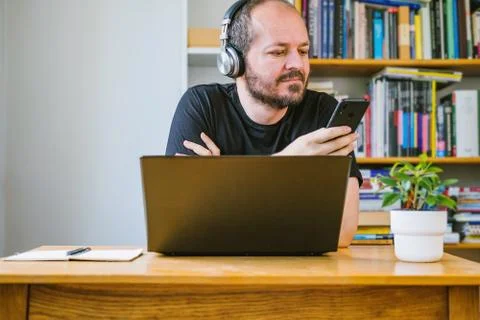 Man working from home office checking smart phone Stock Photos