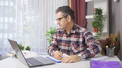 Man working in home office studies taking notes. Stock Footage 221659625