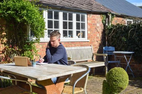 Man working from home remote working online in the garden Stock Photos