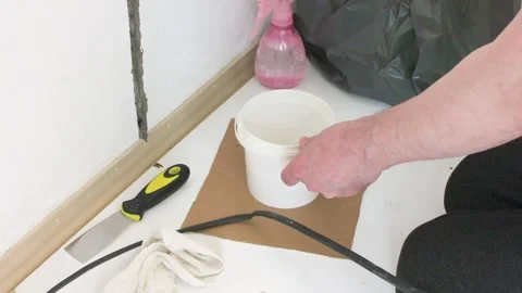A man is working at home, running an electrical cable to a socket. He is en.. Video stock 346148762