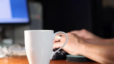 A man working from home sits down at the computer with a cup of coffee Stock-Footage 139691672