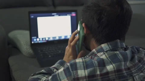 A man working from home use laptop and smartphone in the bed room Stock Footage 146585211
