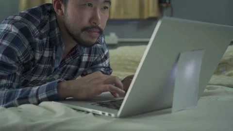 A man working from home use laptop on the bed Stock Footage 146591420