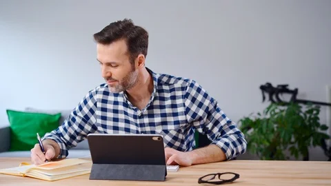 Man working from home using digital tablet Stock Footage 126828397