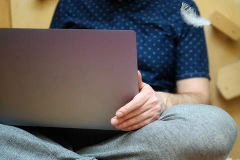 A man working from home using a laptop with his little child playing white fe Stock Photos