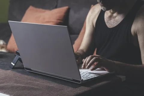 Man working from home using a laptop while sitting on the couch Stock Photos