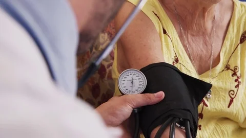 Man Working In Hospice And Measuring Blood Pressure Of Woman Stock Footage 70297492