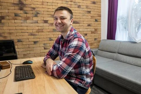 Man working from house at desk with computer. Happy professional freelancer Stock Photos