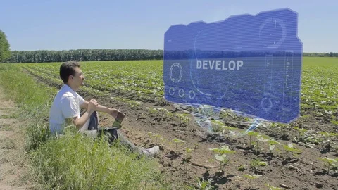 Man is working on HUD holographic display with text Develop on the edge of the Stock Footage 102827609