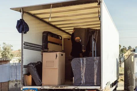Man working inside a white moving truck Stock Photos