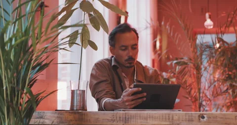 Man working on an ipad in a bar Stock Footage 203582481
