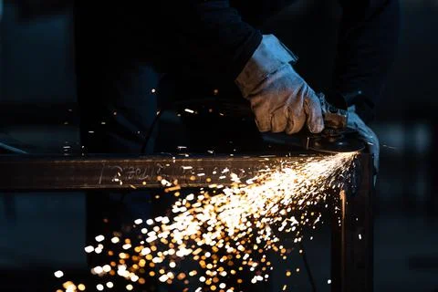 Man working on iron with grinder Fotos de archivo
