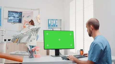 Man working with keyboard and computer with green screen Foto stock