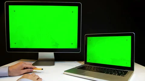 Man Working on the Laptop and Display with a Green Screen  at the Workplace. Stockbeeldmateriaal 52108366