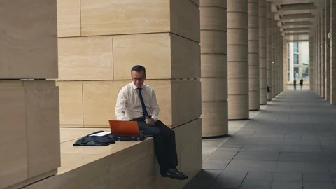 Man working on laptop and drinking coffee outside Stock Footage 92065205