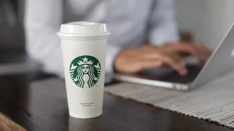 Man working on laptop and drinking Starbucks. Slow Motion. coffee in home office Stock Footage 127796199