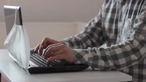 Man is working with laptop and taking off his medical mask Stock Footage 131376504