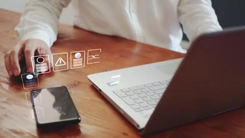 A man is working on a laptop and there is a smartphone nearby. Against this Stock Footage 287562210