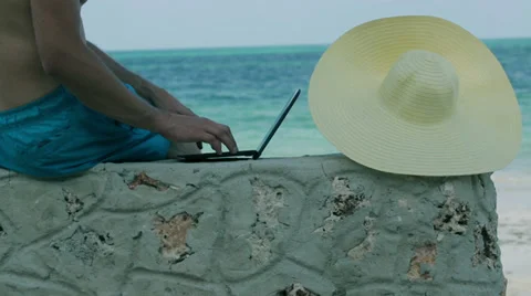 Man working on laptop on the beach Stockbeeldmateriaal 39070563