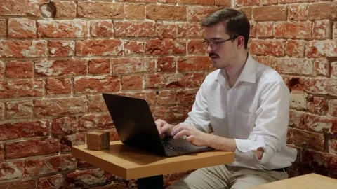 Man working on laptop at brick wall cafe Stock Footage 342779457