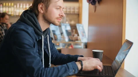 Man is working on a laptop in the cafe Stock Footage 91040653