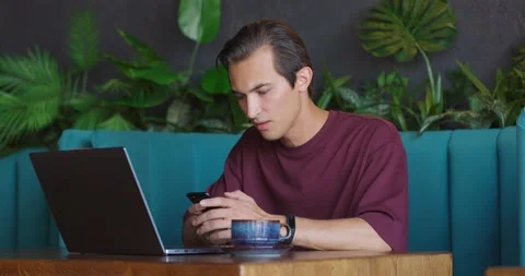 Man working on laptop in cafe.Guy taking phone and getting upset reading bad Stock Footage 164600569