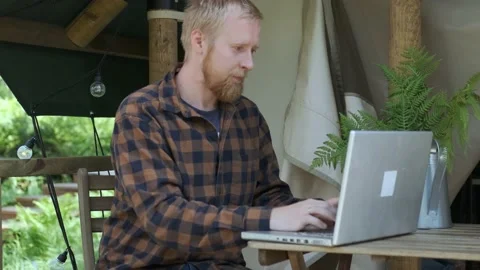 A man working on a laptop in a campsite 스톡 동영상 154280248