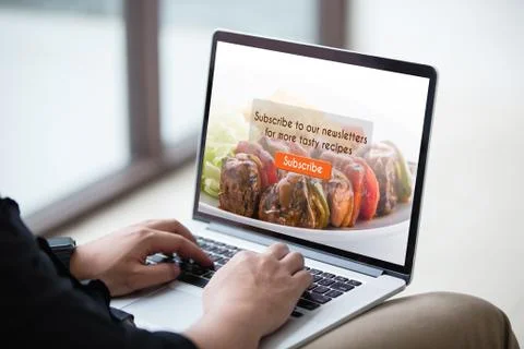 Man working on laptop / computer doing subscribe food blog on screen at office Stock Photos
