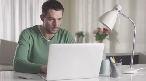 Man is working on a laptop computer at home Stock Footage 61647668