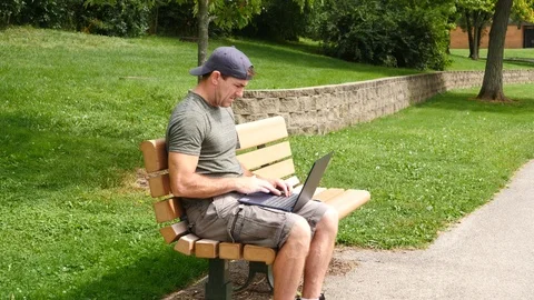 Man working on laptop computer outside good news, happy, 4k, 60fps. Stock Footage 115900680