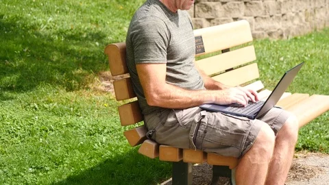 Man working on laptop computer outside thinking writing, 4k, 60fps. Stock Footage 115900698