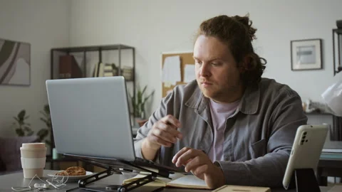 Man Working on Laptop Computer Taking Notes in Office Stock Footage 348142525