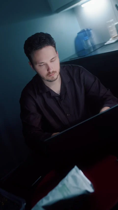 Man Working on Laptop in Dim Kitchen Video stock 322897217